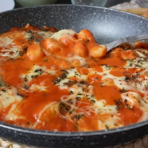 Ñoquis con queso fundido y salsa de tomate listos para servir