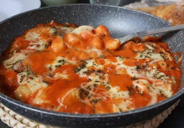 Ñoquis con queso fundido y salsa de tomate listos para servir