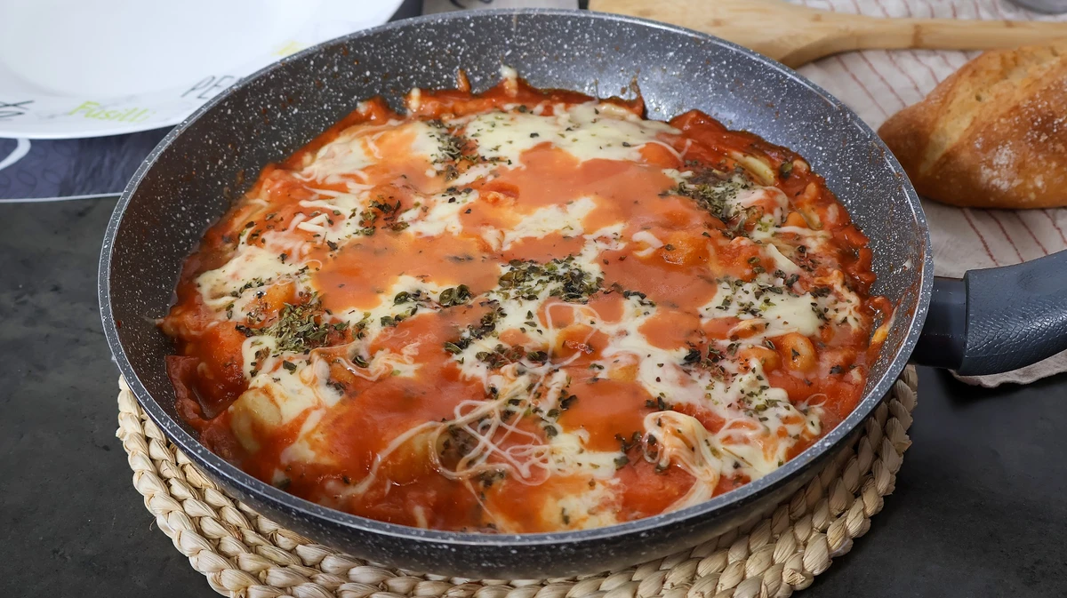Ñoquis con tomate y queso fundido recién hechos en sartén