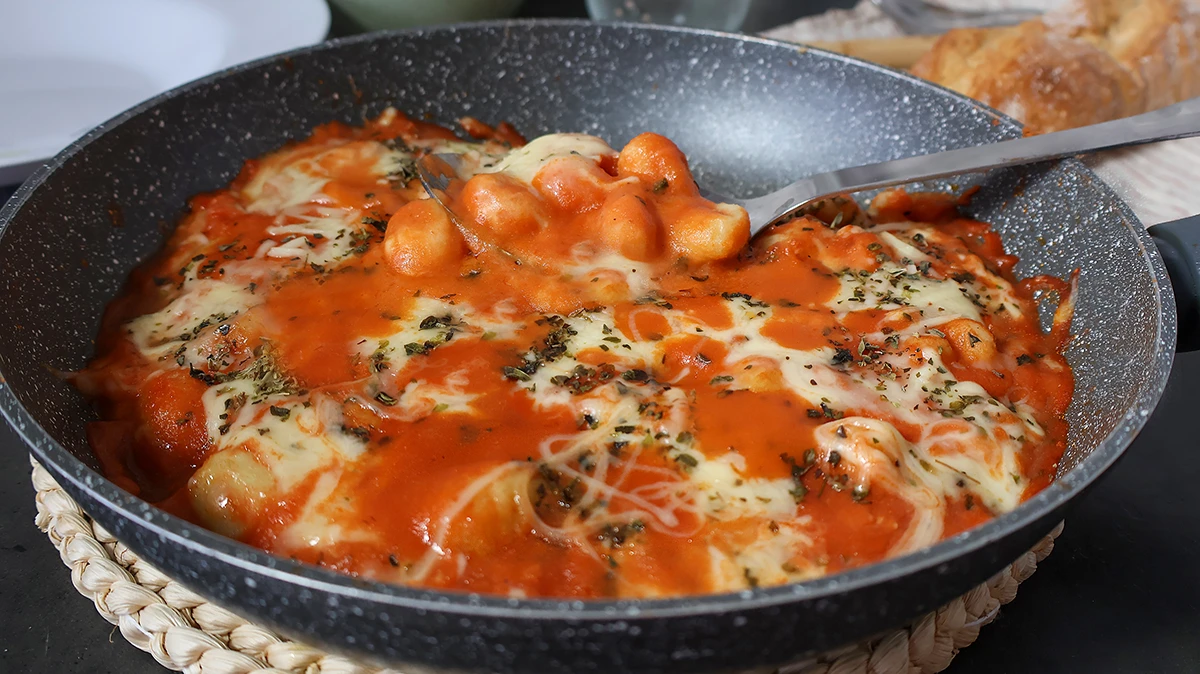 Ñoquis con queso fundido y salsa de tomate listos para servir