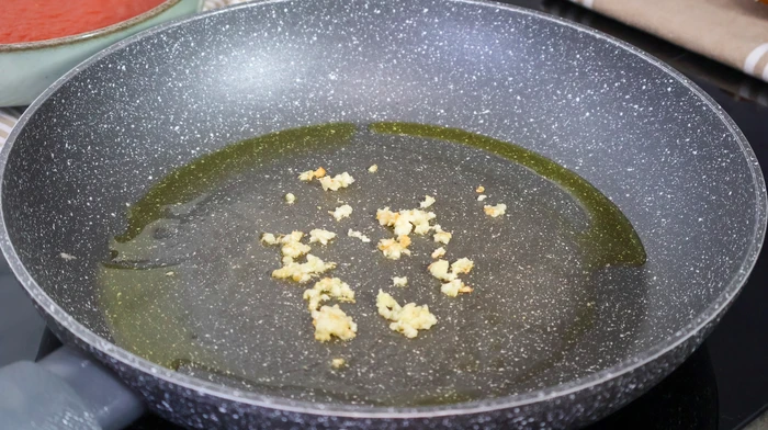 Ajo picado dorándose en sartén con aceite de oliva