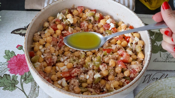 Cucharada de vinagreta sobre ensalada de garbanzos