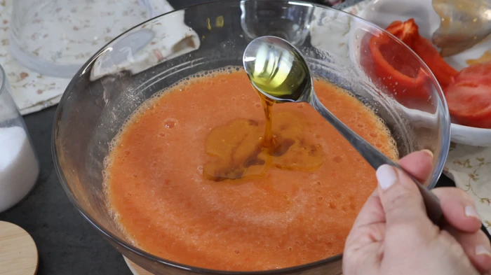 Añadiendo aceite de oliva virgen extra al gazpacho