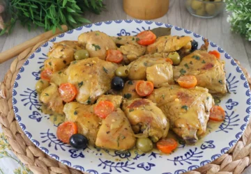 Pollo a la mediterránea servido en fuente con tomates cherry y aceitunas