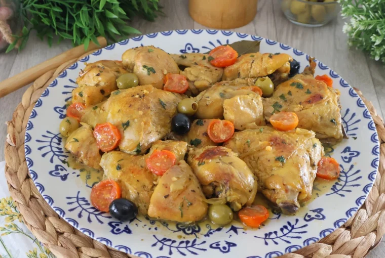 Pollo a la mediterránea servido en fuente con tomates cherry y aceitunas