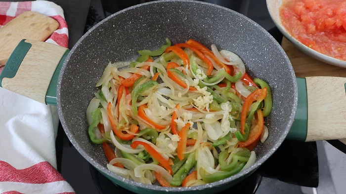 Sofrito de cebolla, pimiento rojo y verde en sartén