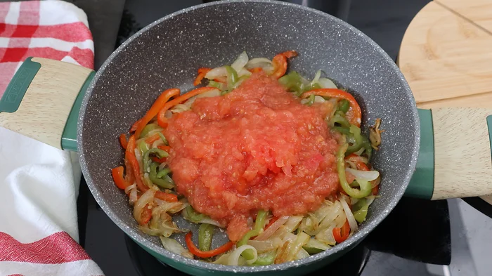 Tomate triturado añadido al sofrito de cebolla y pimiento