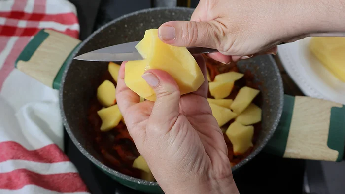 Mano cascando patatas con cuchillo