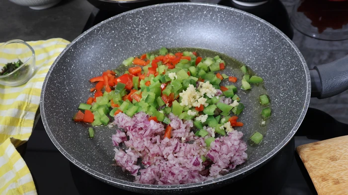 Sofrito inicial de pimiento, ajo y cebolla en sartén