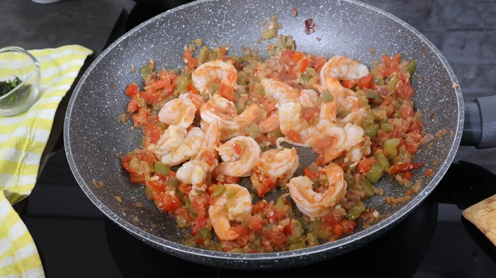 Camarones cocinándose con sofrito de tomate y pimiento