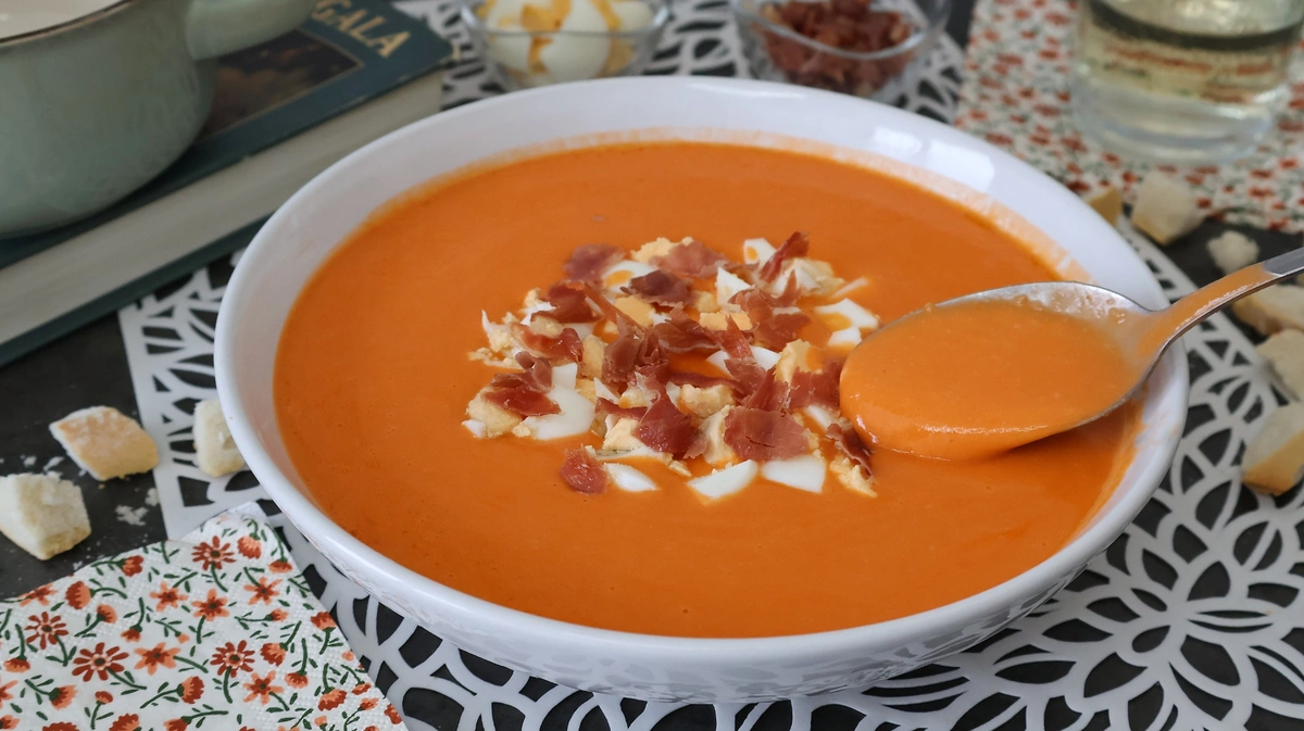 Salmorejo cordobés con jamón y huevo, textura cremosa en cuchara