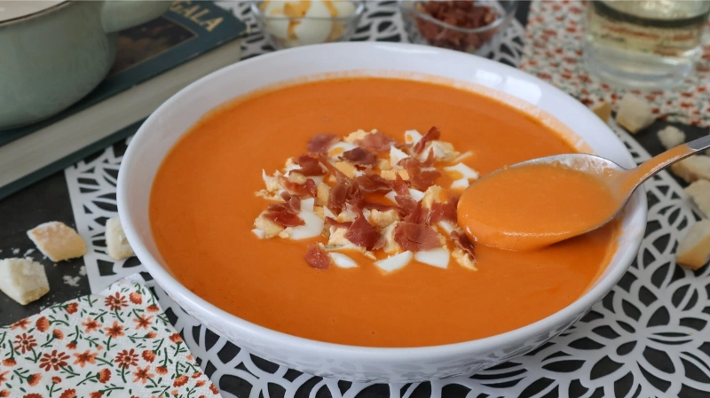 Salmorejo cordobés con jamón y huevo, textura cremosa en cuchara