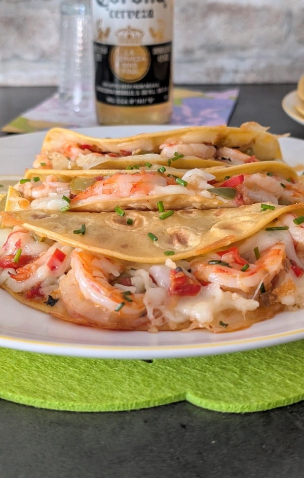 Fuente con tacos gobernados recién servidos, mostrando queso y langostinos