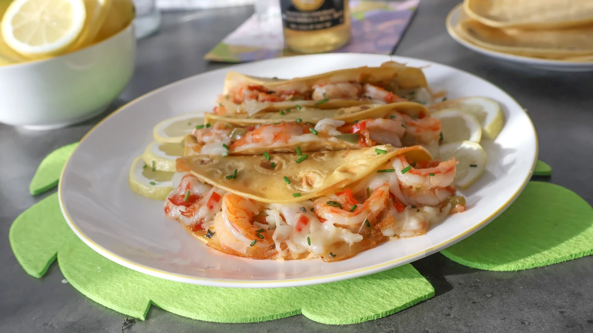 Tacos Gobernador con camarones, queso fundido y tortillas doradas sobre limón en rodajas