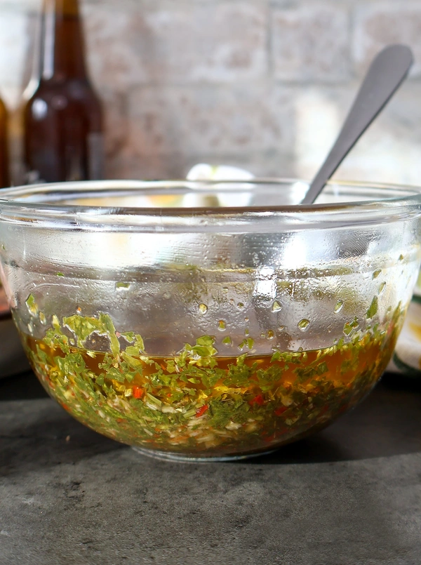 Bol de chimichurri casero reposando con fondo rústico