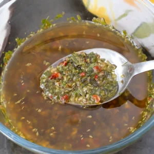 Cucharada de chimichurri mostrando hierbas y ají