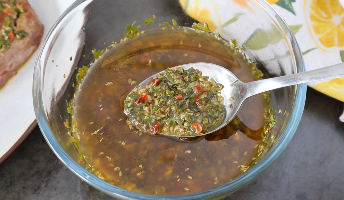 Cucharada de chimichurri mostrando hierbas y ají