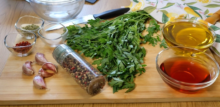 Ingredientes para preparar chimichurri casero sobre tabla de madera