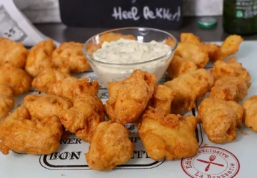 Piezas de bacalao rebozadas y fritas al estilo holandés, servidas con salsa