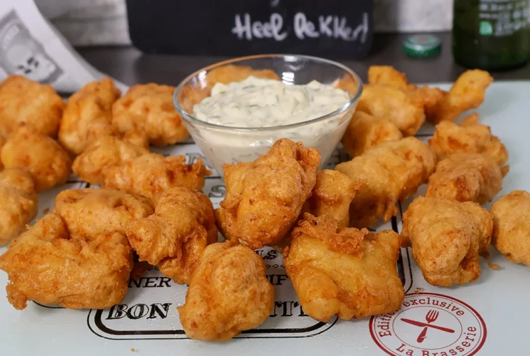 Piezas de bacalao rebozadas y fritas al estilo holandés, servidas con salsa