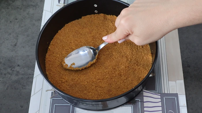 Base de galletas presionada en el molde para la tarta sin horno