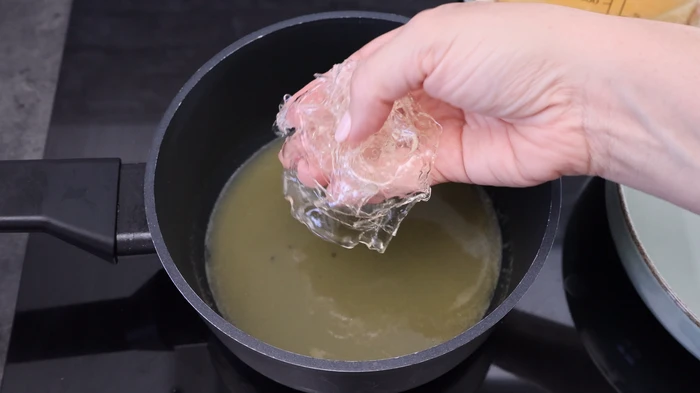 Añadir gelatina escurrida al zumo caliente para la cobertura de la tarta sin horno