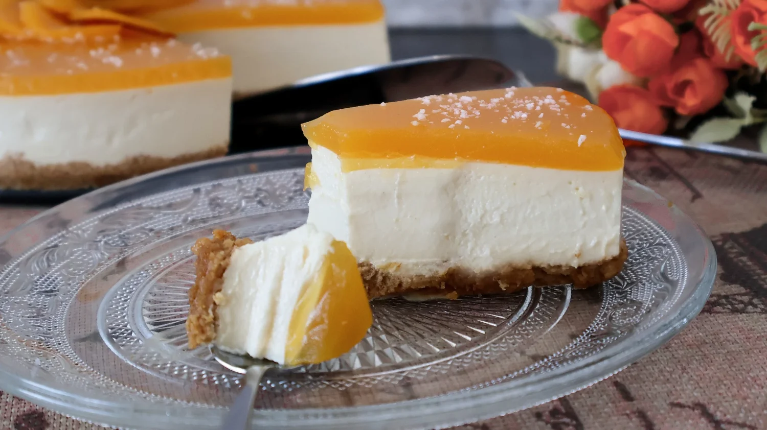 Porción de tarta de queso sin horno con melocotón en un plato de cristal
