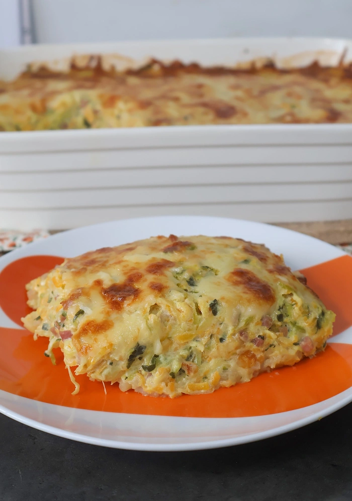 Ración de gratinado de patata, calabacín y calabaza en plato individual