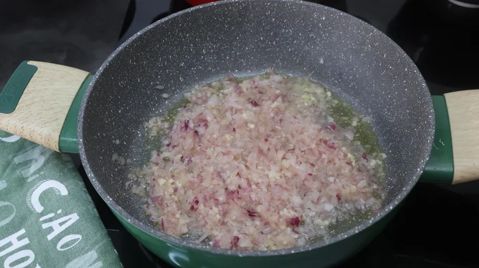 Sofrito de cebolla y ajo en sartén con aceite de oliva