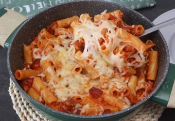 Macarrones con chorizo caseros con salsa de tomate y queso fundido en sartén