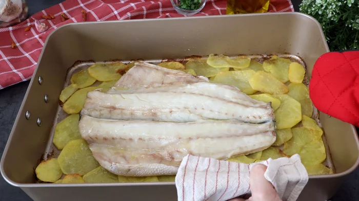 Lubina horneada sobre patatas panadera recién sacada del horno