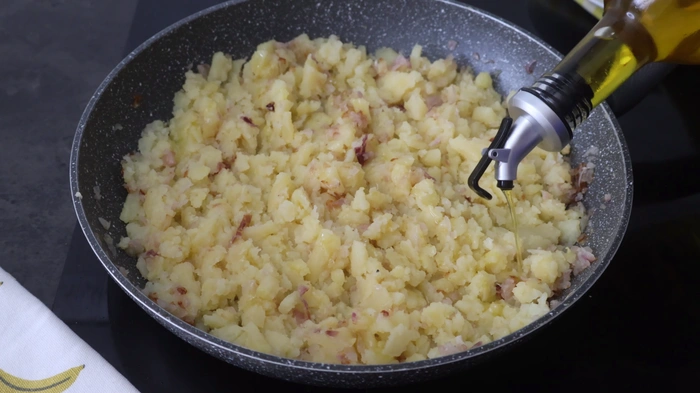 patatas cocidas trituradas con aceite de oliva en sartén