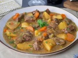 Carne guisada con patatas y verduras en plato hondo, receta tradicional casera