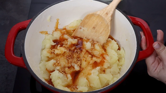 Patatas cocidas mezcladas con el sofrito de ajo y pimentón