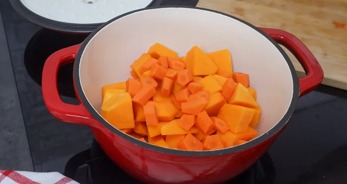 calabaza y zanahoria troceadas en cazuela roja listas para saltear