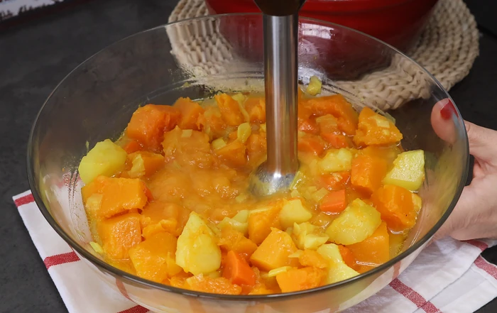 Triturando la calabaza, la zanahoria y la patata cocidas hasta obtener una crema fina