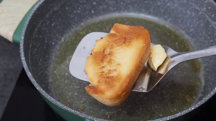 rebanada de pan dorada en sartén con aceite de oliva