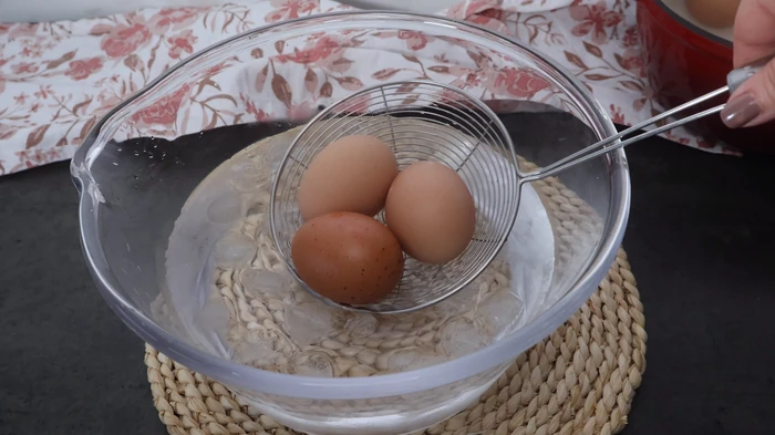 huevos cocidos enfriándose en bol con agua y hielo