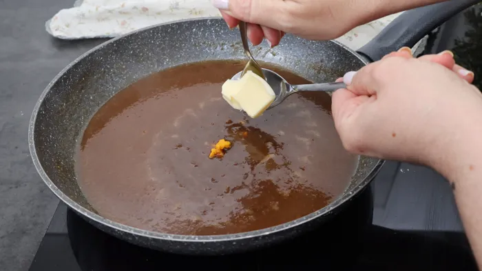 mantequilla y ralladura de naranja incorporándose a la salsa de Pedro Ximénez