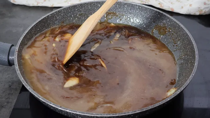 caldo de pollo mezclándose con el Pedro Ximénez y la cebolla en la sartén