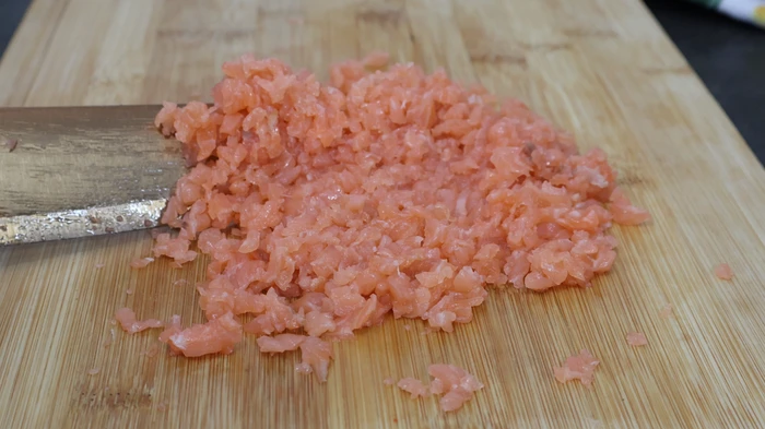 Salmón ahumado finamente picado sobre tabla de madera