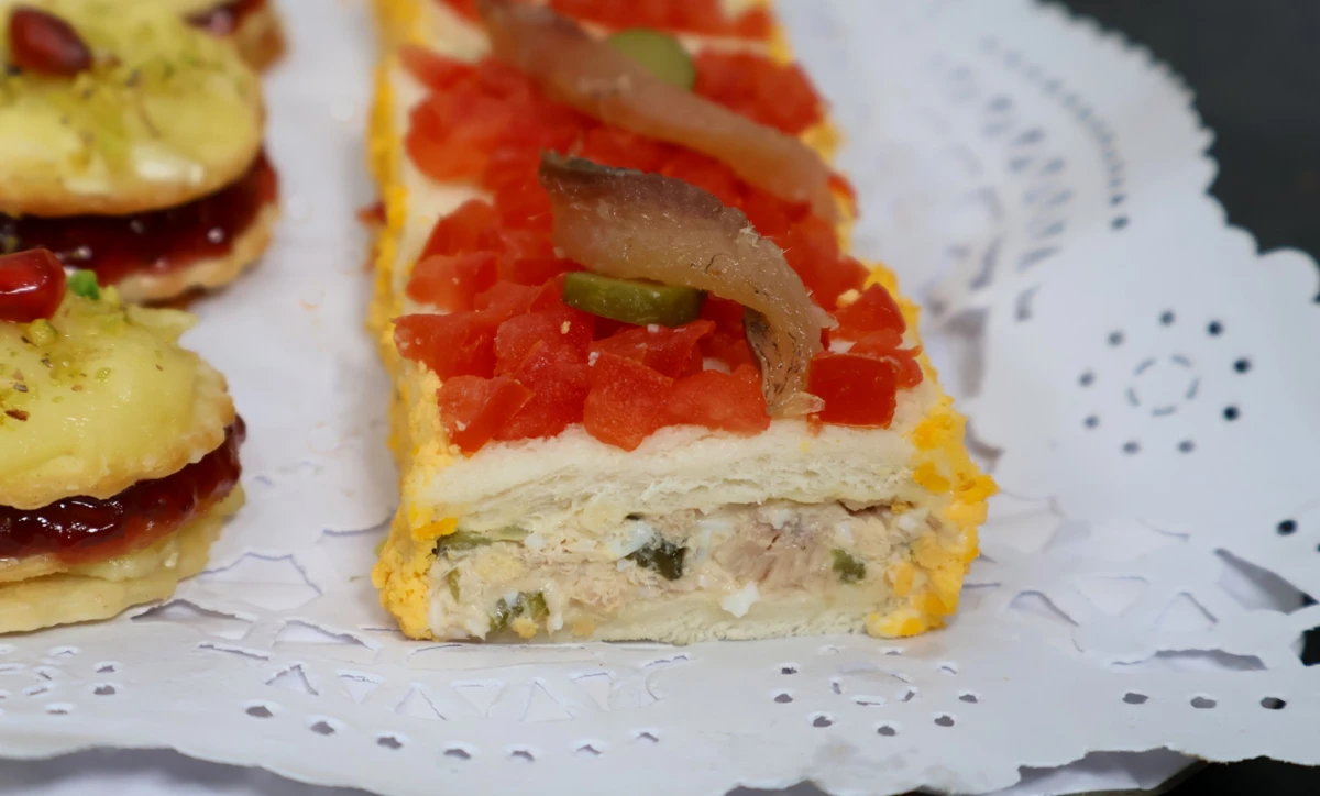 Canapé de atún, pepinillo, huevo y sardina sobre pan de molde
