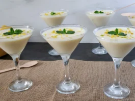 Lemon posset clásico servido en copas, postre británico de limón decorado con ralladura y menta