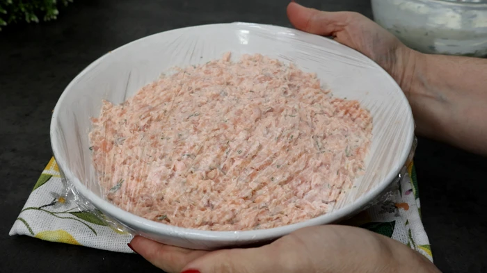 Mezcla de rillettes de salmón tapada con film transparente en bol blanco