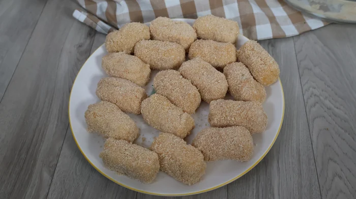 Croquetas de merluza y gambas formadas y rebozadas