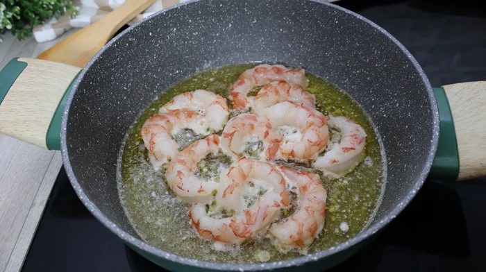 Gambas salteándose brevemente en mantequilla y aceite para croquetas de merluza