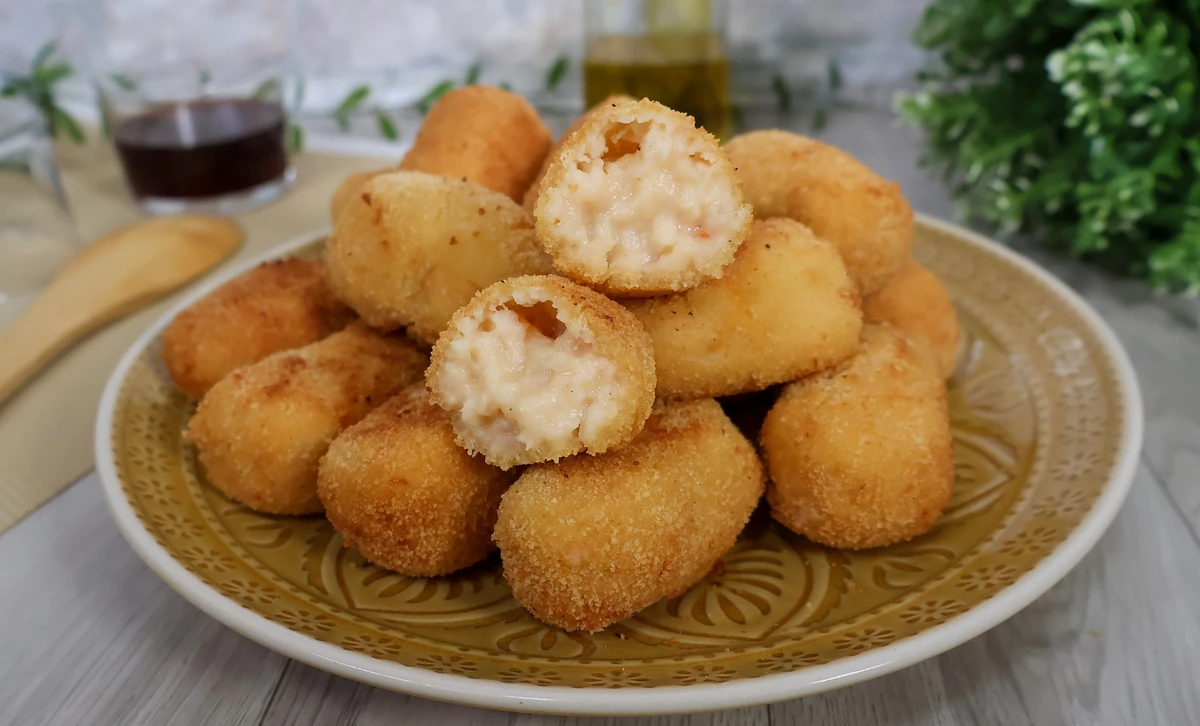 Croquetas de merluza y gambas caseras cortadas mostrando bechamel cremosa interior