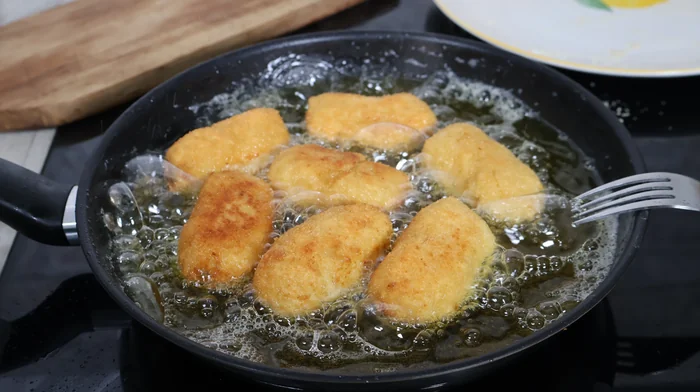 Croquetas friéndose en aceite caliente hasta dorarse