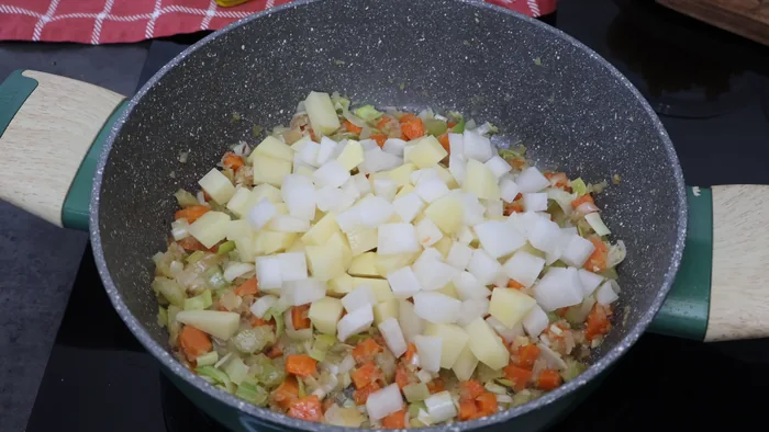 Patata y nabo cortados en cubitos añadidos al sofrito de minestrone
