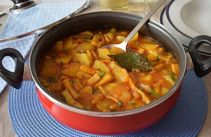 Guiso tradicional de patatas con calamares servido en cazuela